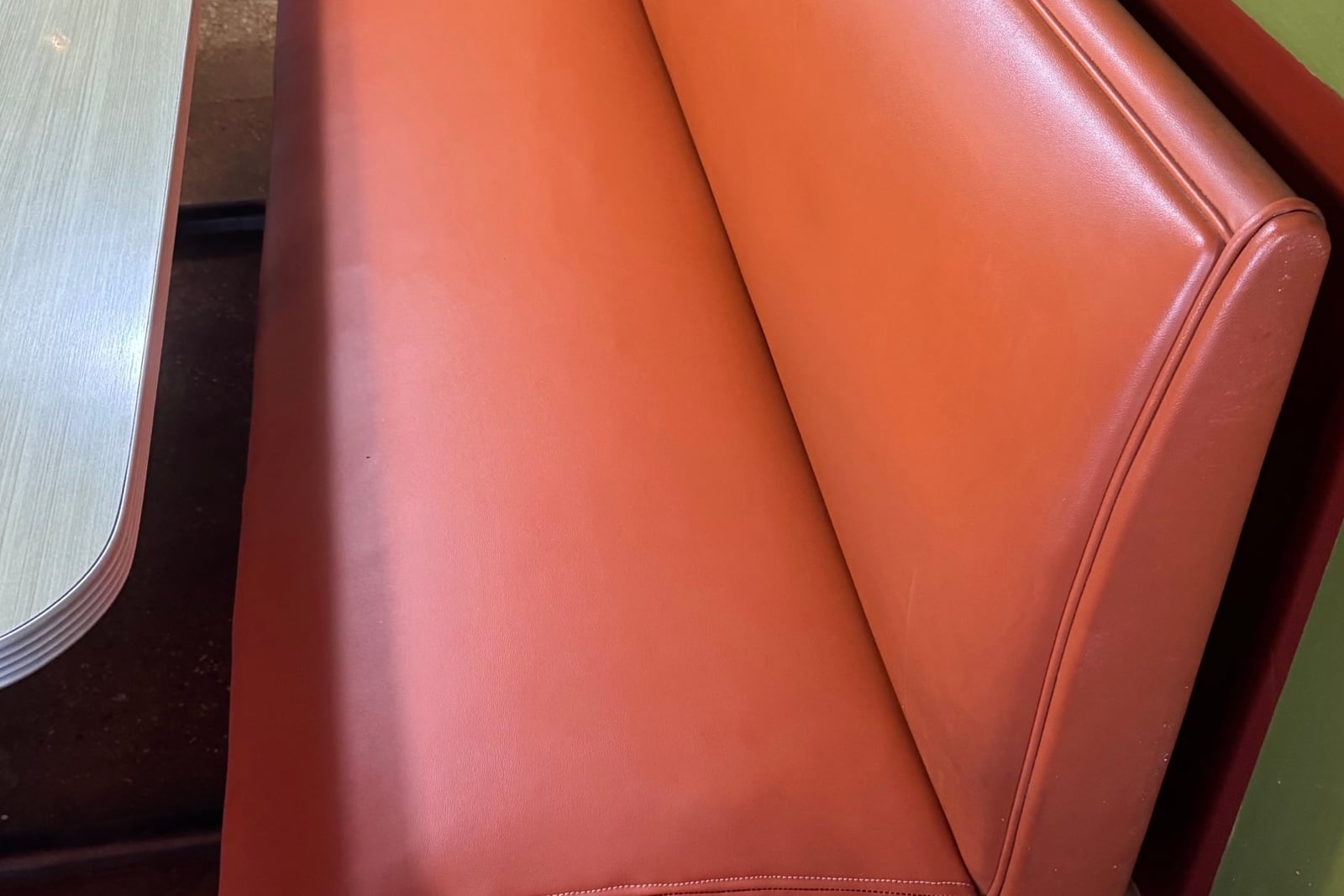 After: Torn seat cushion on a diner bench — before and after repair by Dr. Vinyl DFW