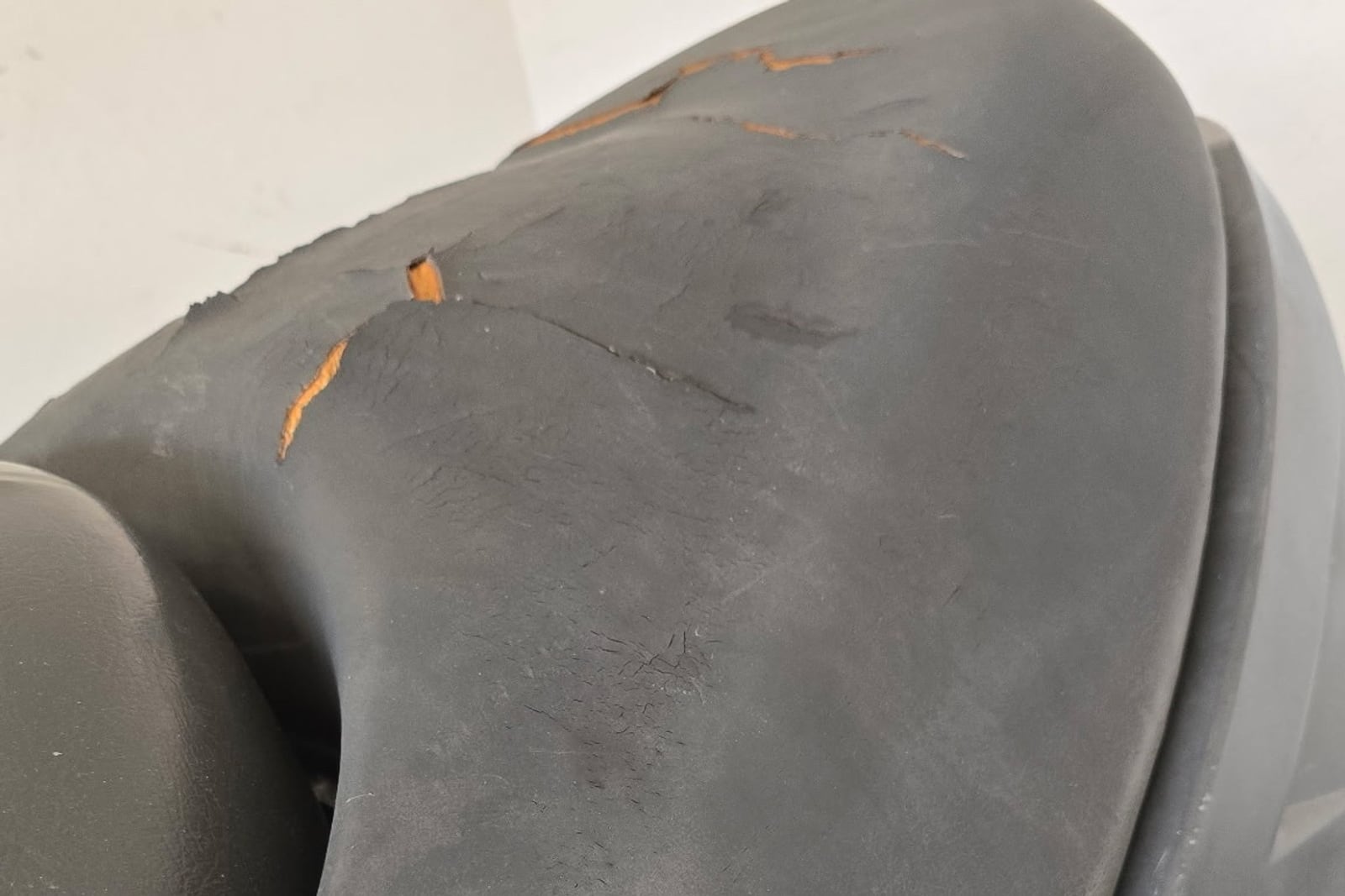 Before: Sun-perished jet ski seat — before and after repair by Dr. Vinyl DFW