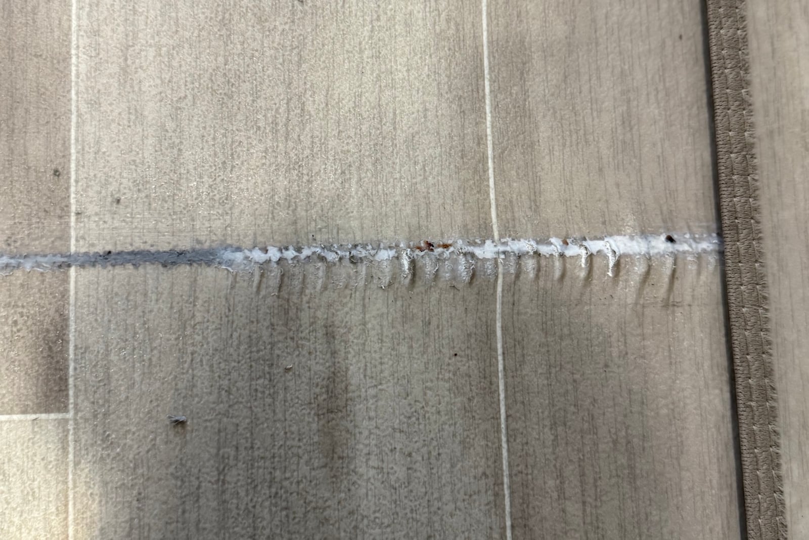 Before: Split seam in vinyl flooring — before and after repair by Dr. Vinyl DFW